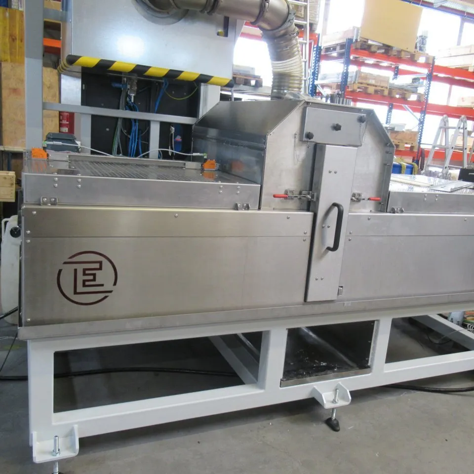 Stainless-steel spray system with spray chamber and conveyor belt, built by Eckardt Systems.