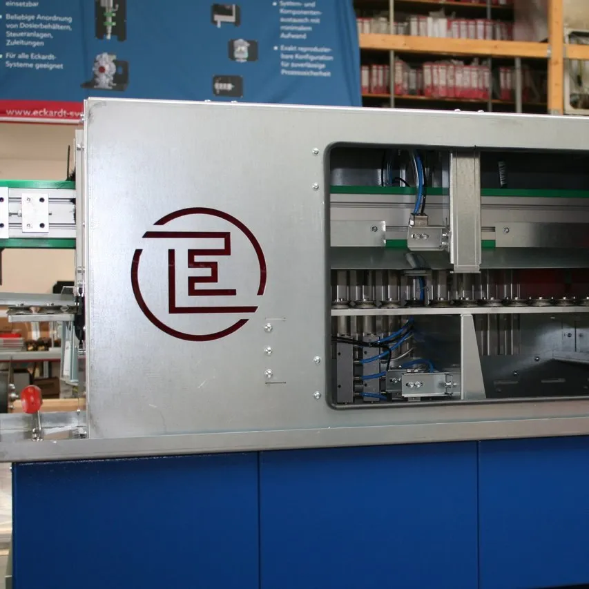 Spray system for plastering trowels with stainless-steel housing, inspection window and Eckardt logo on a blue base frame.