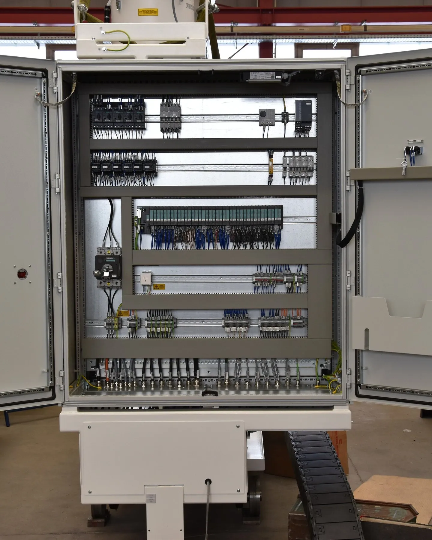 Open control cabinet with PLC I/O and wiring, built at the Eckardt plant.